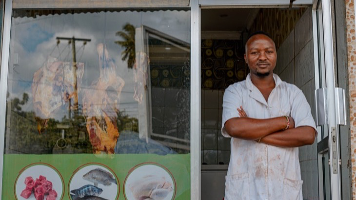 Small business owner standing confidently outside his storefront